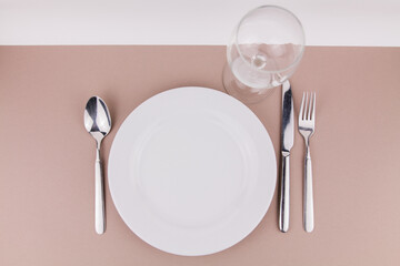 table setting plate fork spoon and knife on gray background white plate