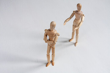 one wooden mannequin trying to make it up with another one