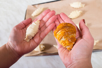 Raw and baked croissants in hand. Home made croissants.