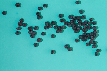 Blueberries from the freezer are frozen and poured on a blue surface
