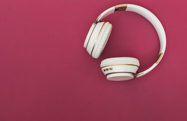 wireless headphones white on fuchsia background with music and relaxation