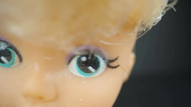 Closer look of the eyes of the baby toy with the blonde hair