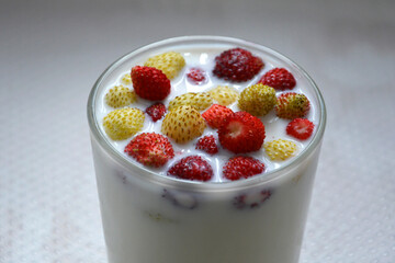 Glass of milk with strawberries close-up. Fruit healthy natural drink.
