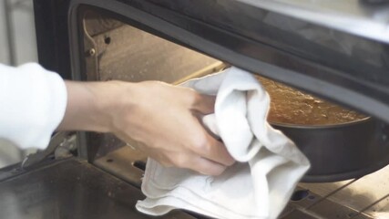 Taking out a baked cake from the oven, slow motion