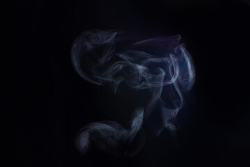 A cloud of steam from hot water on a black background