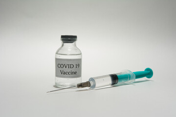 Covid 19 vaccine bottle and syringe on a white background.