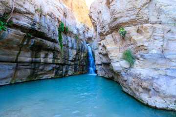 Flowing water to a large pool of clear water, in the hidden waterfall in Nahal Arugot, Ein Gedi Israel route