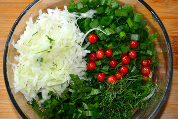 Salad. Vegetable salad in a glass bowl. Chopped vegetables and currant berries. Cabbage and greens.