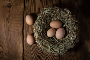 Easter eggs in a basket on a vintage wooden background. eggs in the nest with copy space