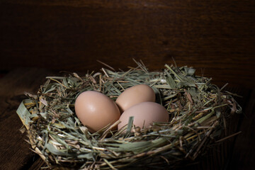 Easter eggs in a basket on a vintage wooden background. eggs in the nest with copy space