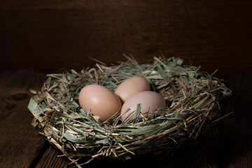 Easter eggs in a basket on a vintage wooden background. eggs in the nest with copy space