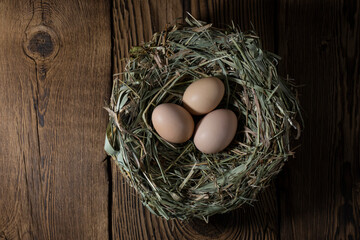 Easter eggs in a basket on a vintage wooden background. eggs in the nest with copy space