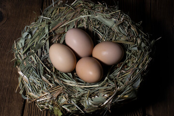 Easter eggs in a basket on a vintage wooden background. eggs in the nest with copy space