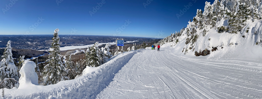 Wall mural Panoramic aerial view of Mont and Lake Tremblant in winter with skiers on slope downhill, Quebec, Canada