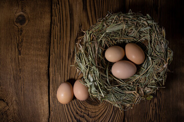 Easter eggs in a basket on a vintage wooden background. eggs in the nest with copy space