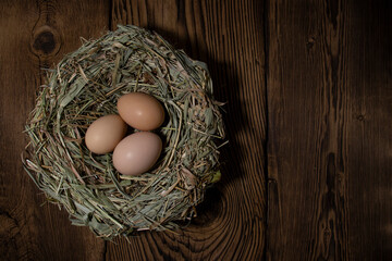 Easter eggs in a basket on a vintage wooden background. eggs in the nest with copy space