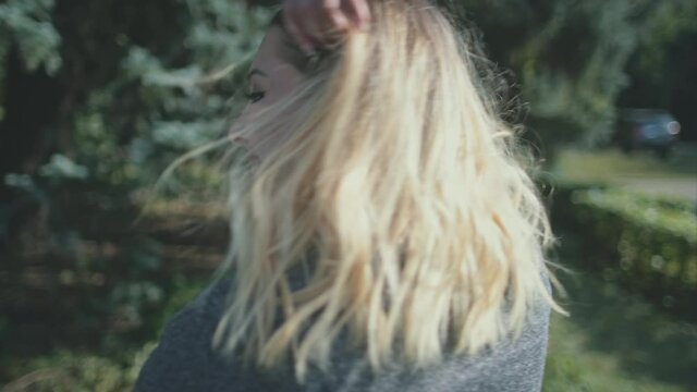 Closeup sensual smile of blond woman plus size. Nature landscape. Body positive people. Happiness model girl at sun leaves trees. Laughing lady in grey dress. Hapy lifestyle. Portrait cinematic shot