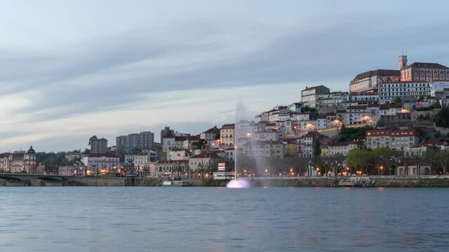 Timelapse of Coimbra at sunset with color light fountain in mondego river, in Portugal