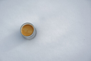 Expresso dans une tasse transparente posée sur la neige