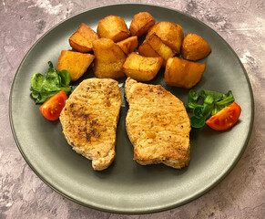Pork cutlets, also known as pork chops with fried potatoes.