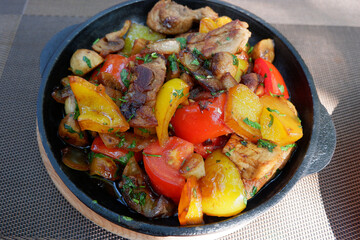 Home-style roast. Meat skillet with tomatoes and bell pepper