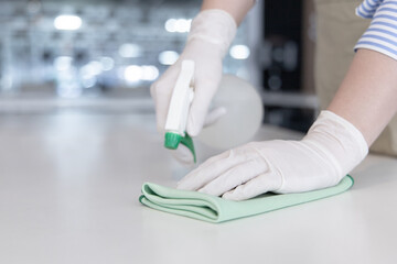 Close up Staff hand Restaurant workers are cleaning table and spraying disinfectants during the virus outbreak, Using cleaning solutions or using alcohol to kill germs in the restaurant.
