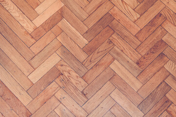 Parquet wooden old scratched floor with herringbone pattern