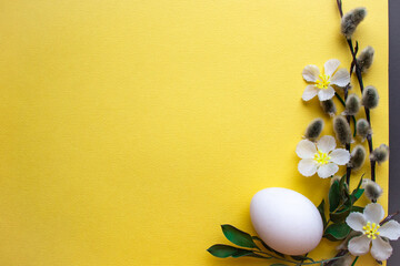 Easter poster. Egg, flowers, branches of a palm tree on a yellow background