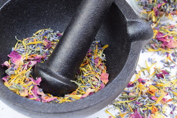 Fragrant herbs in mortar and spoiled out from jar on white wooden background, alternative medicine...