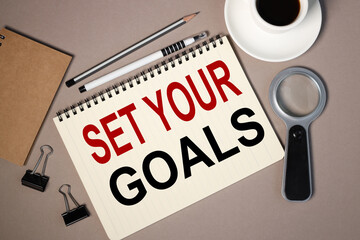 set your goals. text on notepad on brown background