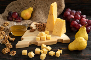 Cheese, pears and nuts on a wooden cutting board