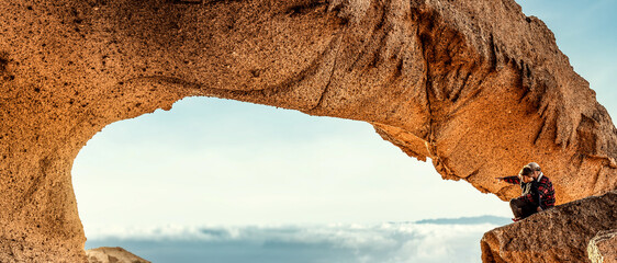 Family father and son hiking, picturesque stone arches and unique rock formations in Tenerife....