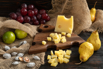 Cheese, pears and nuts on a wooden cutting board