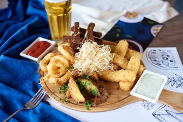 beer appetizer, cheese, crackers, fried fish pieces, two sauces