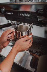 Fototapeta na wymiar bartender preparing hot milk on coffee machine