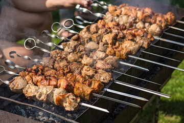Asian barbecue outdoors. Marinated meat on skewers is fried over coals.