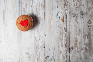 small cupcakes with hearts on a wooden background. concept for valentine. sweet pastries