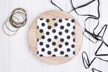Serwetka w czarne kropki na drewnianej desce © Seance_Photo_Sylwia