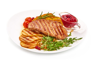Roasted beef steak with potato wedges, grilled pears and arugula salad with feta cheese, isolated on white background