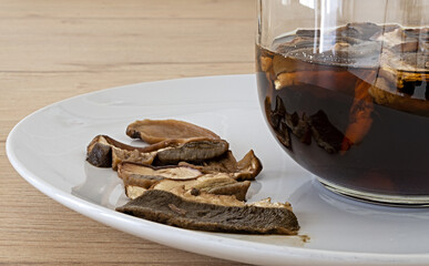 piatto e tazza di vetro con funghi porcini secchi in ammollo vista fronte