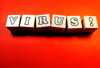 The inscription VIRUS on wooden cubes on a red background.
