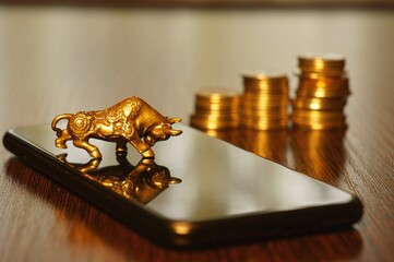A metal bull and a mobile phone on the table.