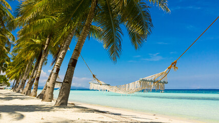 Tropical landscape: beautiful beach with hammock and tropical sea. Panglao island, Bohol, Philippines. Summer and travel vacation concept.