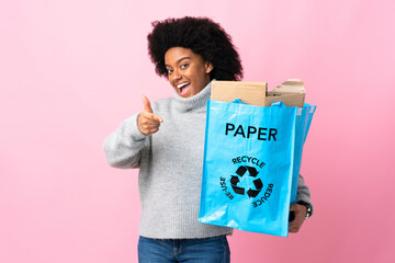 Young African American woman holding a recycle bag isolated on colorful background pointing to the front and smiling