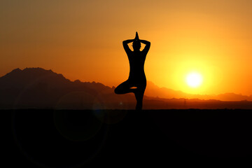 Frau meditiert im Sonnenuntergang