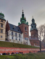 Wawel Royal Castle walls in historic center in the city of Krakow. People and grey sky. Planty Park (planty krakowskie). Poland. Europe