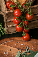 Red cherry tomatoes in a food photography scene with wood basket and details in background