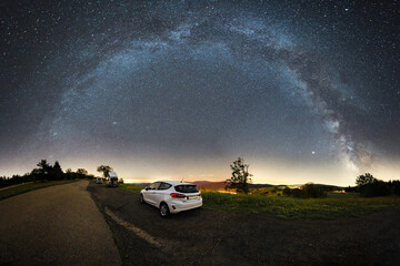 car in front of the milky way panorama shot on the schauinsland near freiburg