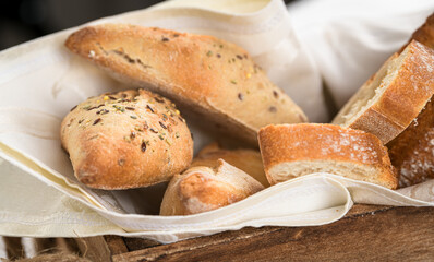 Close up view of a wood basket with homemade bread and slices, food photography details