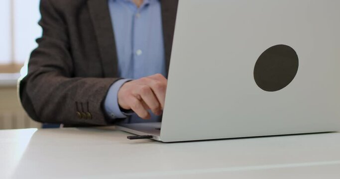 A man in a suit inserts an electronic access key into a laptop slot and puts his finger on the flash drive's sensor. Modern password encryption technologies.